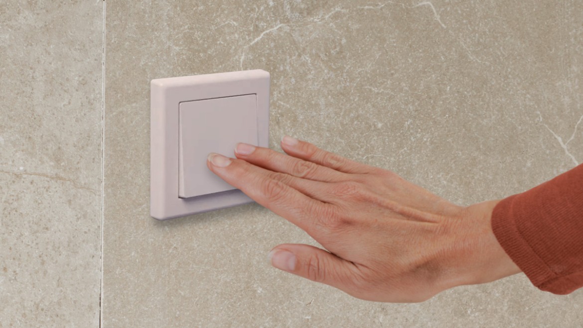 Electrical push-button remote flush being operated by hand